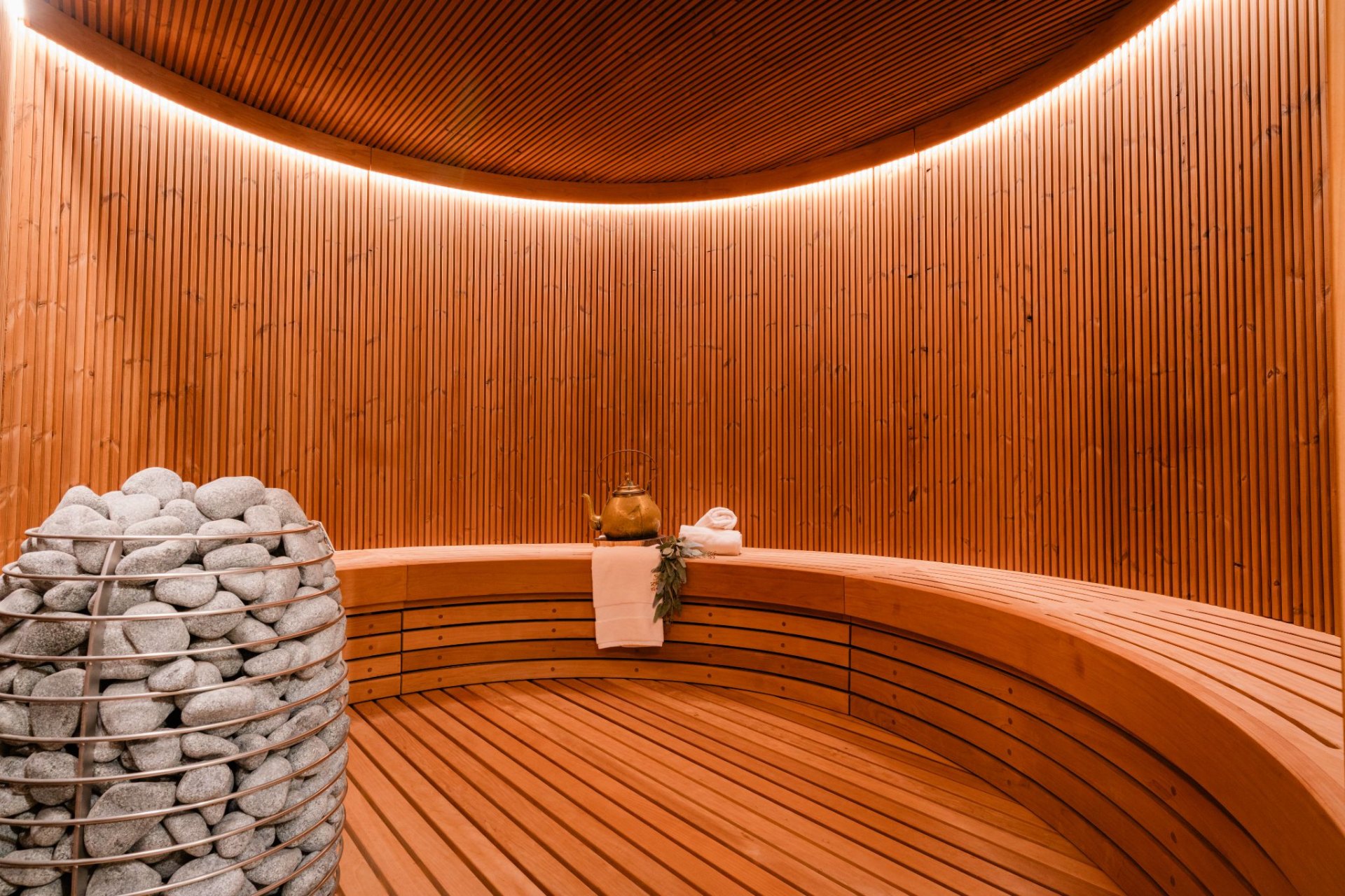 Custom cedar sauna interior with glass front and stone surround